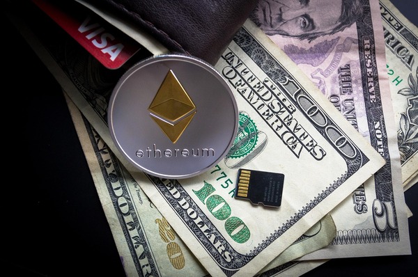Ethereum coin, US dollar banknotes and a leather wallet